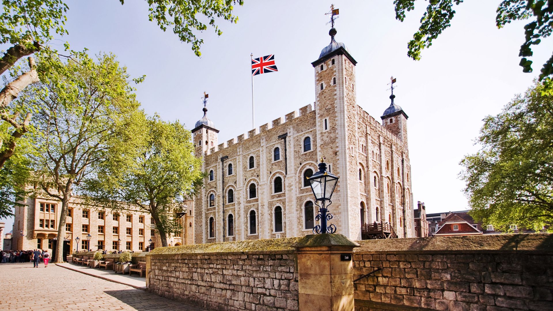 The white brick walls and tall towers of the historic medieval palace at the tower of London. 