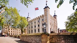 La White Tower, un grand bâtiment blanc situé au milieu de la Tour de Londres, arbore le drapeau de l'Union Jack.
