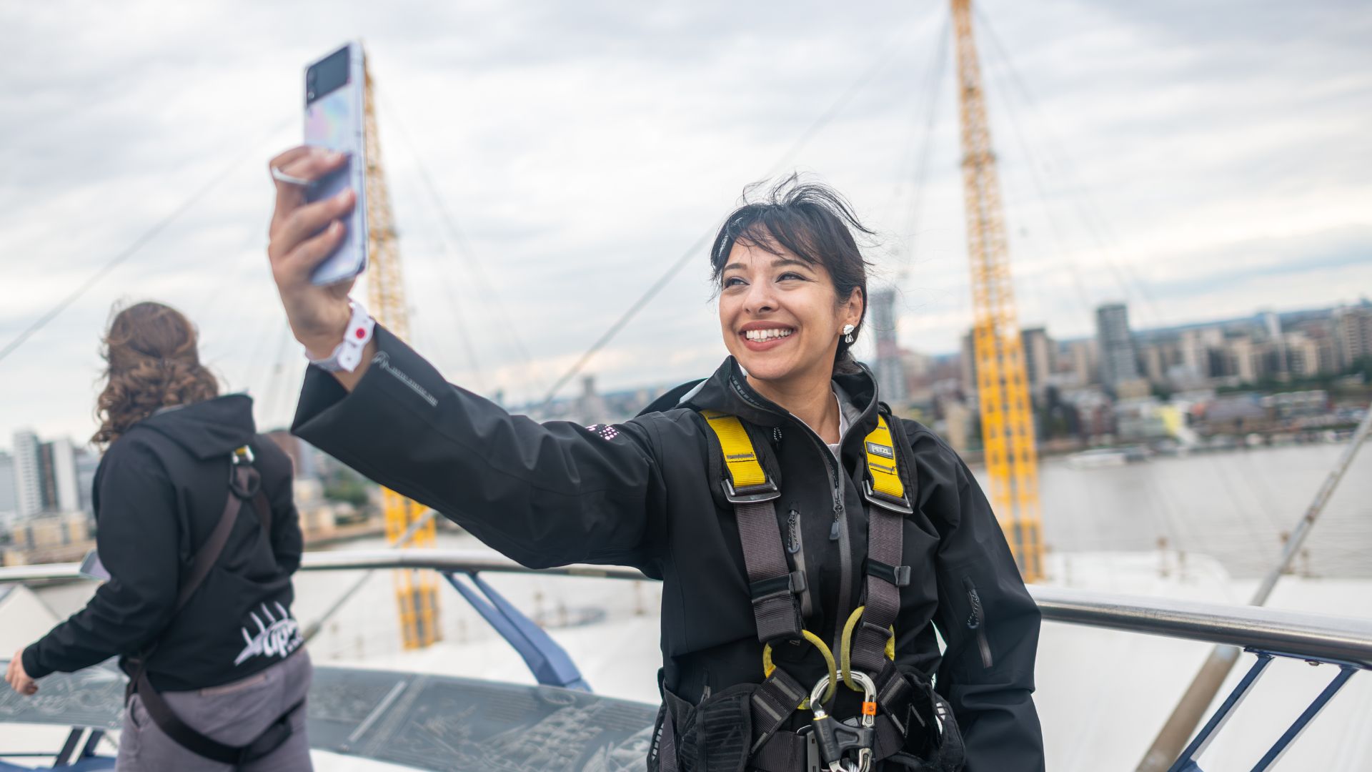 Capturing the moment at the summit of Up at The O2, with sweeping views of London as the perfect selfie backdrop. Image courtesy of London & Partners/Michael Barrow A visitor takes a selfie at the top of Up at The O2 with views of the River Thames and Canary Wharf skyline behind.