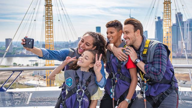 Family of four take a selfie on top of the O2 stadium in london.