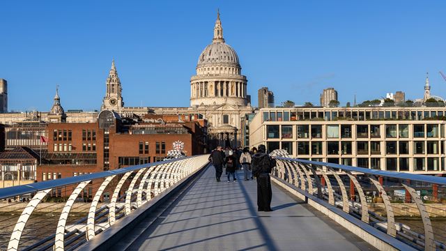 People admiring the views from the Millennium Bridge with St. Paul's Cathedral in the foreground.