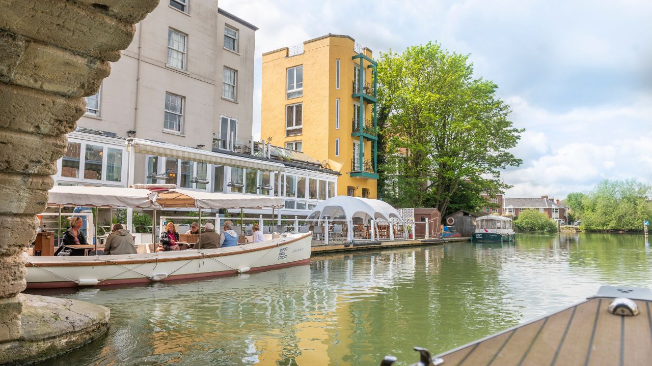 Boats lined up against a white building on the river thames in oxford.