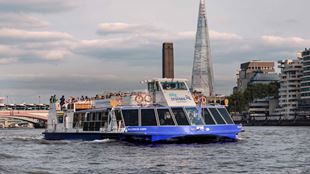 Das Sightseeing-Boot von City Cruises fährt auf der Themse, während im Hintergrund das Shard emporragt.