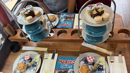 Savour a Smurf-themed afternoon tea featuring colourful treats and drinks aboard The Smurfs London Tea Party Adventure bus. Image courtesy of Golden Tours.