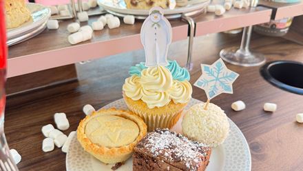 Admire London sights and enjoy festive treats on The Snowman™ afternoon tea bus, featuring cupcakes, mince pies and indulgent chocolate bites. Image courtesy of Golden Tours.