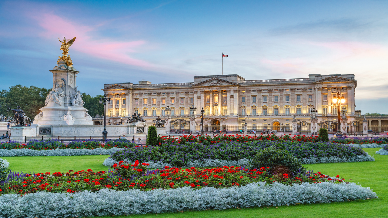 Admirez le Palais de Buckingham, résidence officielle du Roi Charles III. Image courtesy of Visit London/ Credit: Jon Reid Le PalaisLe Palais de Buckingham est illuminé en début de soirée avec de beaux parterres de fleurs l'entourant. de Buckingham Palais est illuminé en début de soirée avec de beaux parterres de fleurs l'entourant.