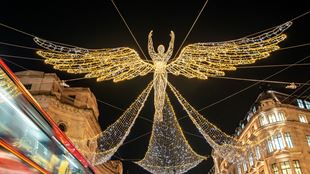 L'un des anges de Noël de Regent Street est suspendu au-dessus de la rue, étincelant dans la nuit.