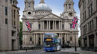 Hop-on hop-off bus driving through central London.