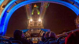 Tourists on the London By Night bus tour approaching Tower Bridge