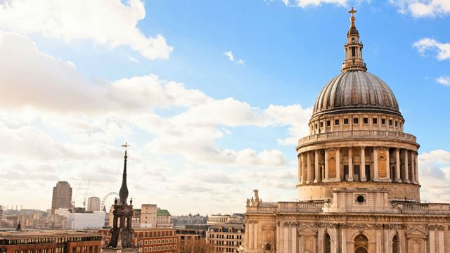 A photo of St Paul Cathedral's dome with panoramic view of London and blue skies.