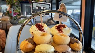 A plate of cakes and pastries with taylor swift icons on an afternoon tea bus tour in London.