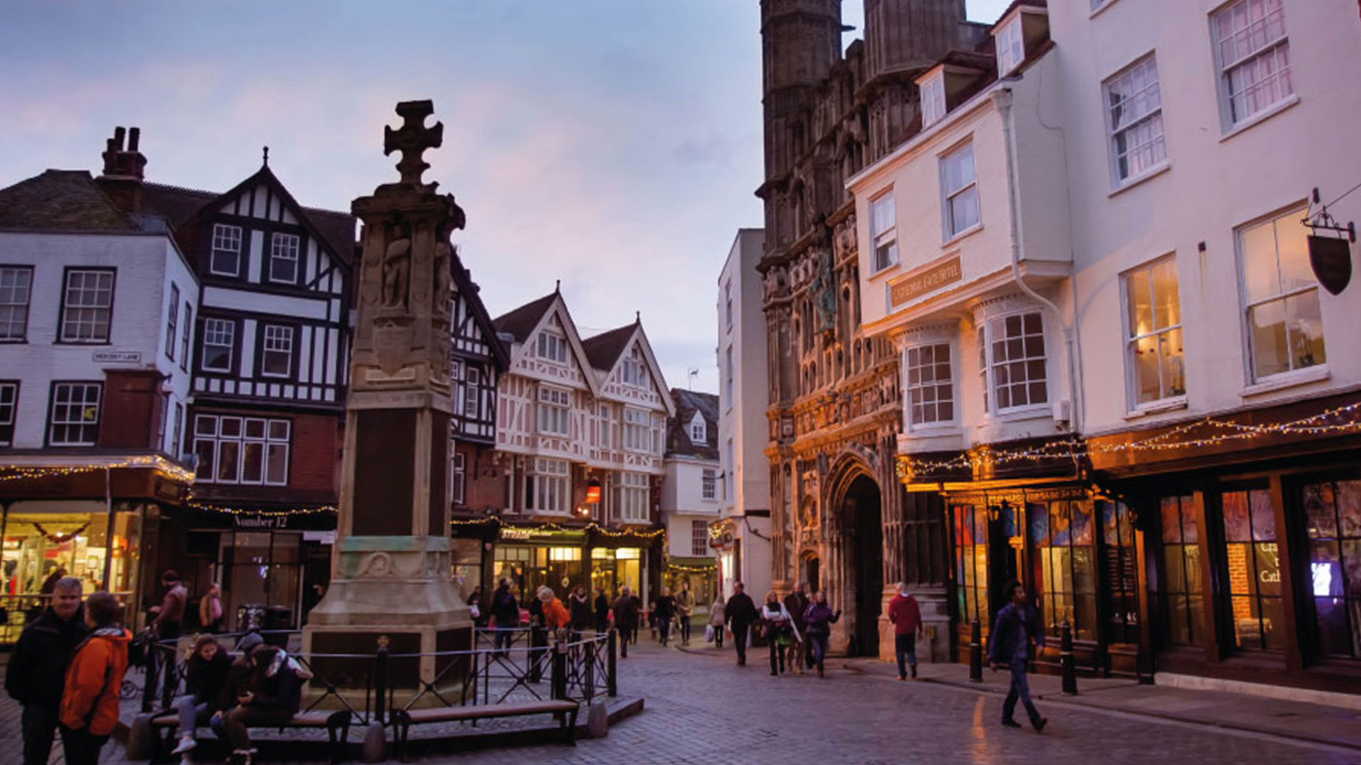 Canterbury market in the evening with Christmas decorations and a market stall in the background.