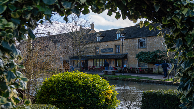 Visitez les villages des Cotswolds, une campagne anglaise magnifique. Avec l'aimable autorisation de Simon Godfrey sur Unsplash. Pub de campagne bordant une rivière à Burton-on-the-Water, situé dans les Cotswolds, région célèbre pour ses cottages pittoresques.