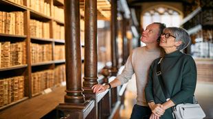 Two people look at books in the Duke Humfrey's Library at Bodleian Library in Oxford