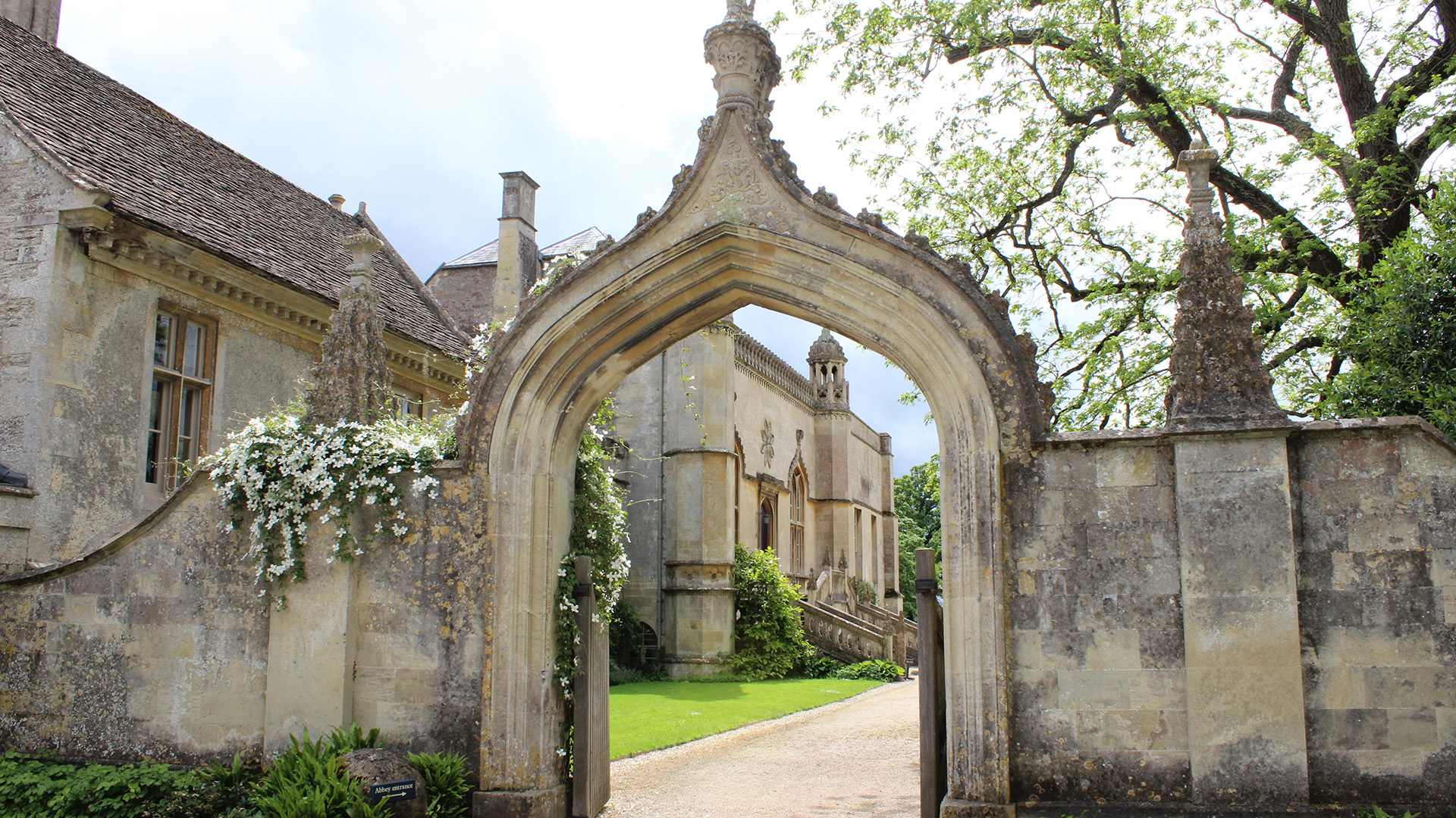 Venture through Lacock Abbey. Image courtesy of Shutterstock. Part of the wall of Lacock Abbey with a famed entry into the Abbey gardens.