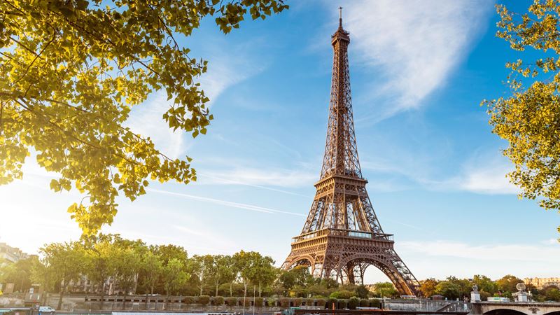 A view of the Eiffel Tower from across the river Seine on a bright day.