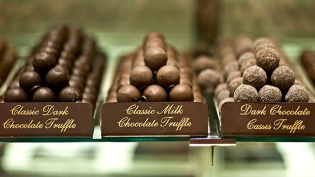 A selection of chocolate truffles on a shelf.