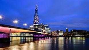 Vue de nuit sur la Tamise et les monument illuminés de Londres dont le Shard à l'arrière plan.