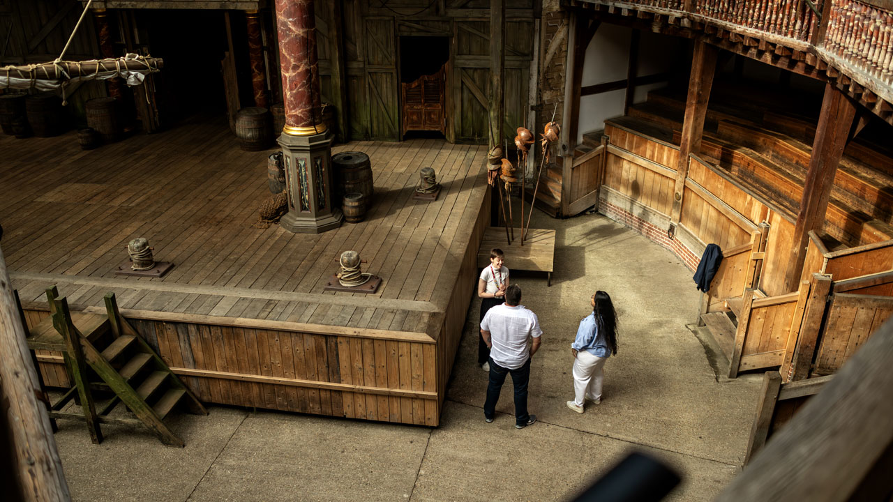 Explore the world of Shakespeare and discover the ingenious structure of the Globe Theatre on a guided tour. ©London & Partners/Michael Barrow Two people and a tour guide were seen from the balcony overlooking the stage of the Shakespeare Globe Theatre.