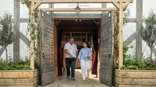 Un homme et une femmes discutent avec animation alors qu'ils sortent du Shakespeare Globe Theatre.