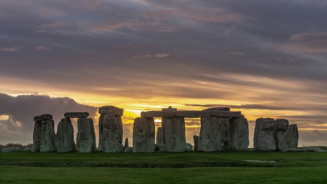 The stones at Stonehenge with the sun setting.