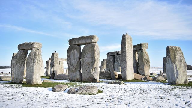 Stonehenge covered in a little snow on a bright day.