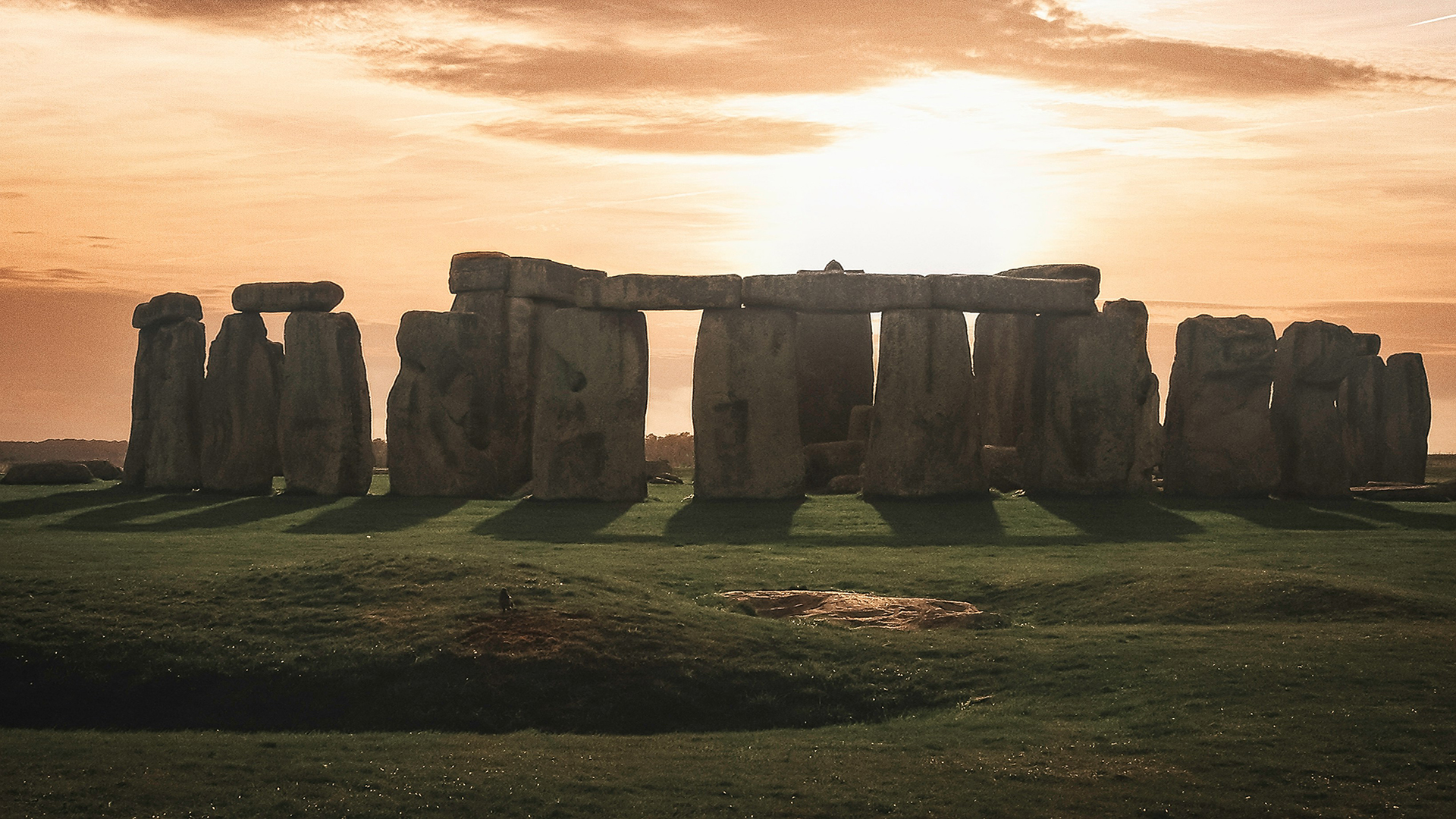 Enjoy the sun rise over the stones at Stonehenge. Image courtesy of Unsplash, credits: K Mitch Hodge A close view of the stones showing a sunrise at Stonehenge.