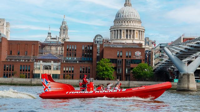 Thames Rockets boat passing St Paul's Cathedral on the river Thames.