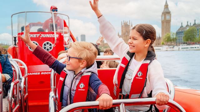 Two children waving to the side on a Thames Rockets experience with Big Ben in the background.