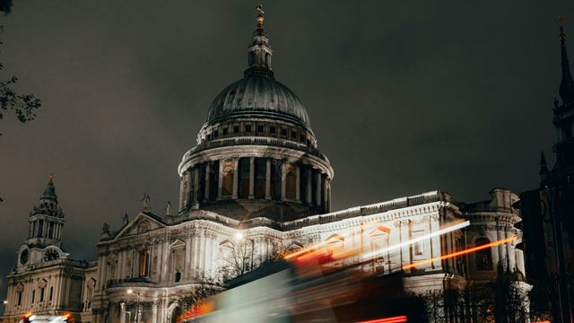 St Paul's Cathedral at night, with a bus speeding past