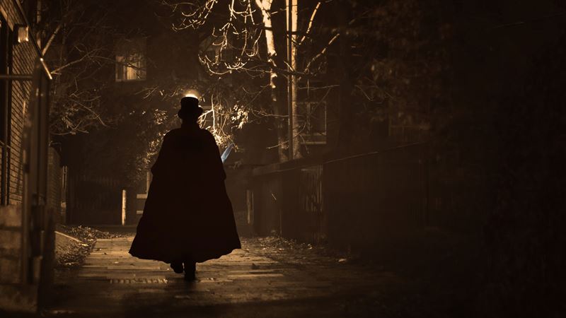 Go on a guided Jack the Ripper Walking Tour. Image courtesy of Golden Tours. A dark figure, assumed to be Jack The Ripper walking the dark alleys of East London, is wearing a top hat and a long cloak.