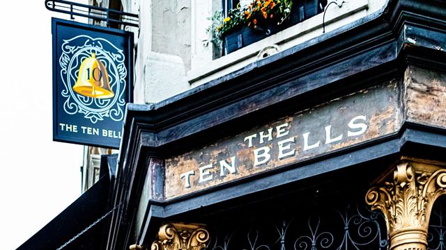Blue painted facade of the Ten Bells Pub with gold columns