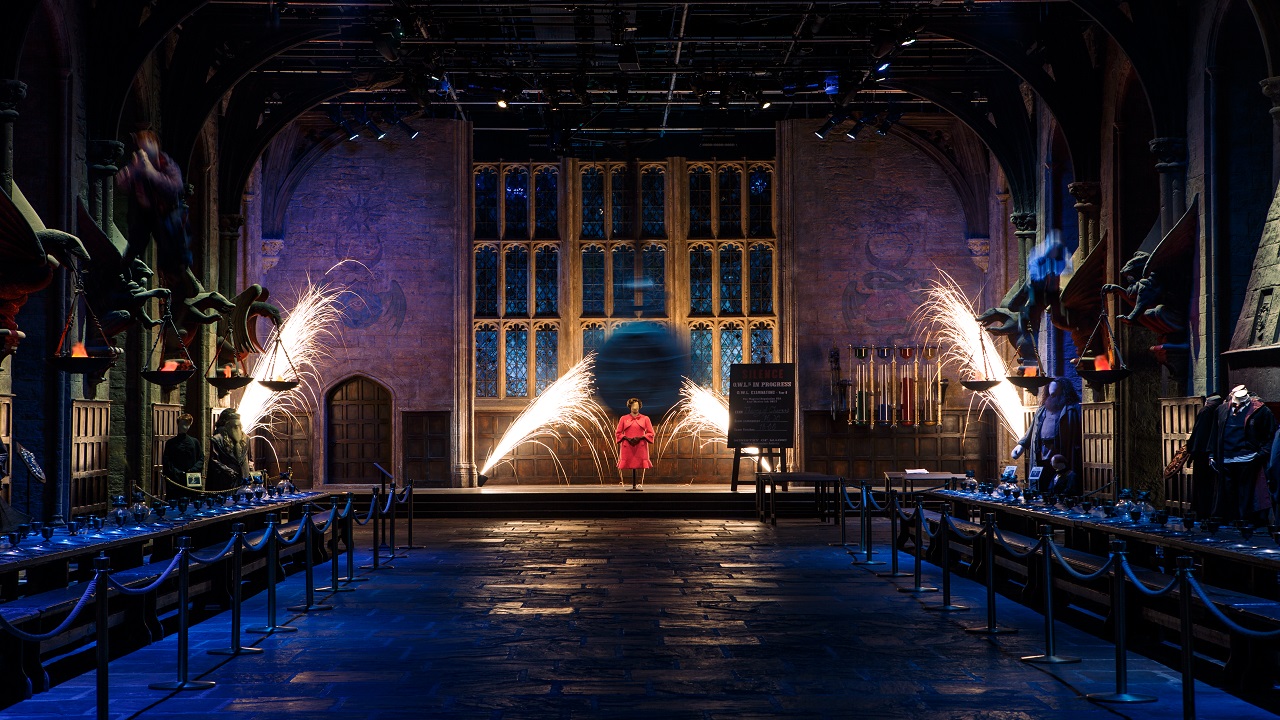 Découvrez la Grande Salle de Poudlard transformée lors de l'événement Magical Mischief. TM & © Warner Bros. Entertainment Inc. Harry Potter Publishing Rights © JKR. La Grande Salle de Poudlard et lieu de tournage aux Warner Bros. Studio Tour est transfomée avec une série d'accessoires et de costumes pour l'événement Magical Mischief.
