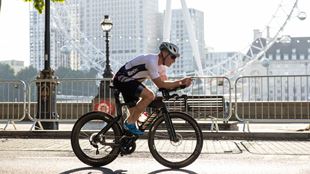 A single cyclist passes the iconic London eye on their way around the city track on a bright and cloudy day. Image courtesy of OCD Studios.