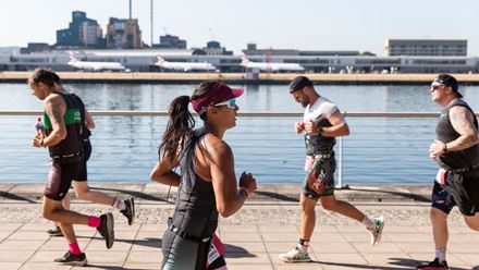 Runners run down the royal docks past City Airport. Image courtesy of OCD Studios.