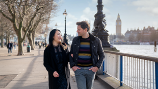 A man and woman walking along Embankment with Big Ben in the background