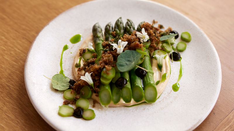 Relish seasonal vegetables at Michelin Green Star restaurant, Apricity in Mayfair, London. Credit: Paul Richardson. Image courtesy of Apricity. A dish of Bedlam Farm asparagus, cashew cream, black garlic and focaccia crumb from Apricity in Mayfair.