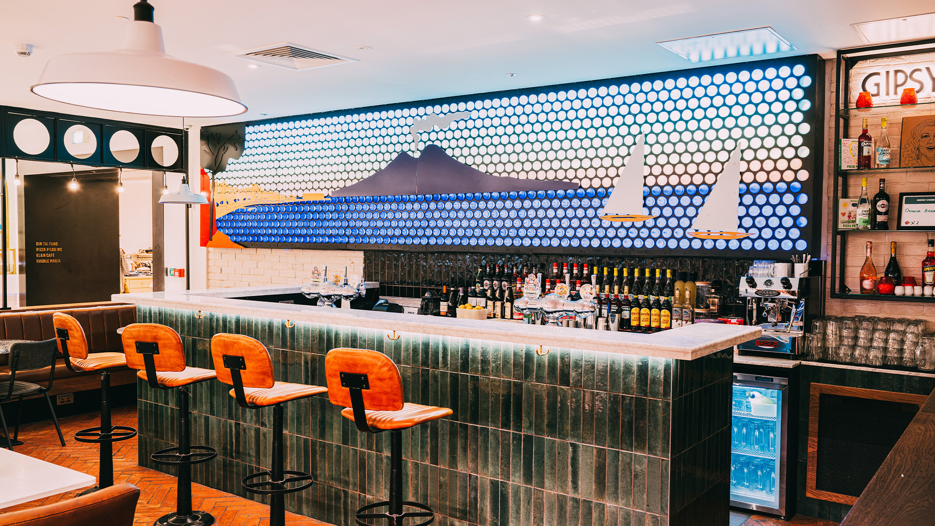 The bar at Pizza Pilgrims features a giant mural of the Bay of Naples, made using 2,000 recycled glass water bottles. 