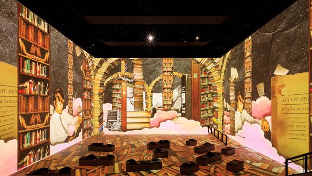 The interior of Lightroom showing David Bowie reading and surrounded by books on the 360-degree screens.