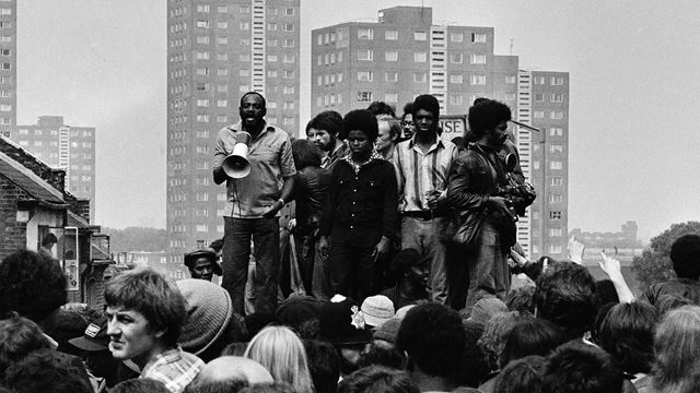 Black and white photograph of Darcus Howe addressing the anti-racist demonstrators in 1977.
