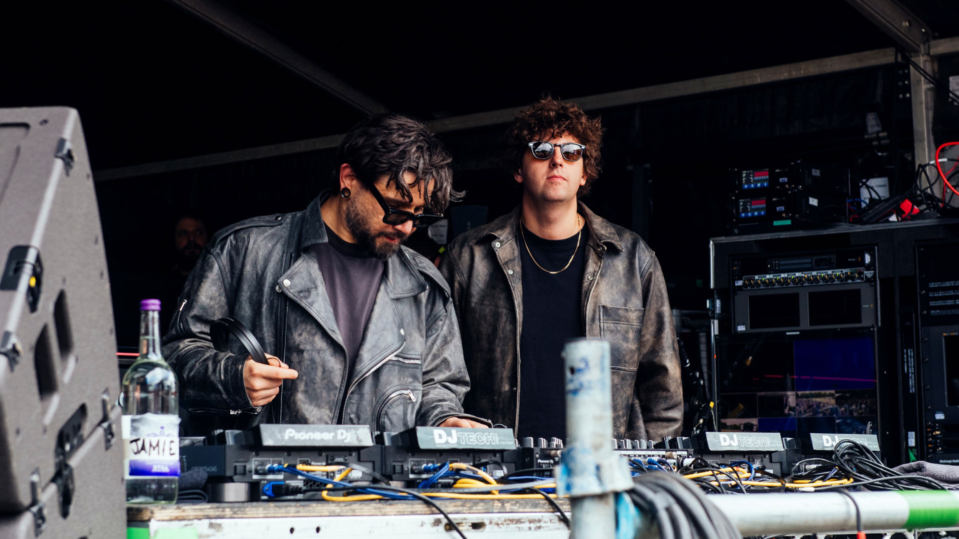 A photo of Skrillex and Jamie XX onstage at LIDO Festival with DJ decks and speakers in front of them 