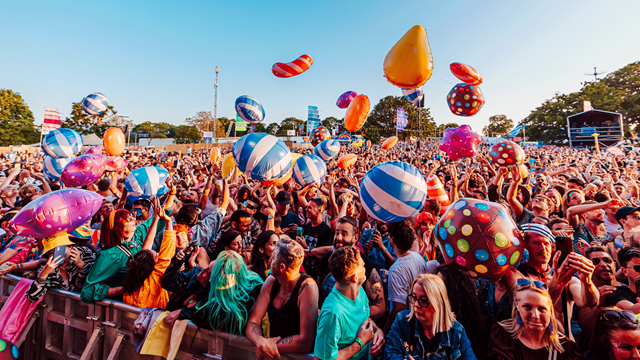Giant inflatable beach balls float over the colourful festival crowd at Mighty Hoopla
