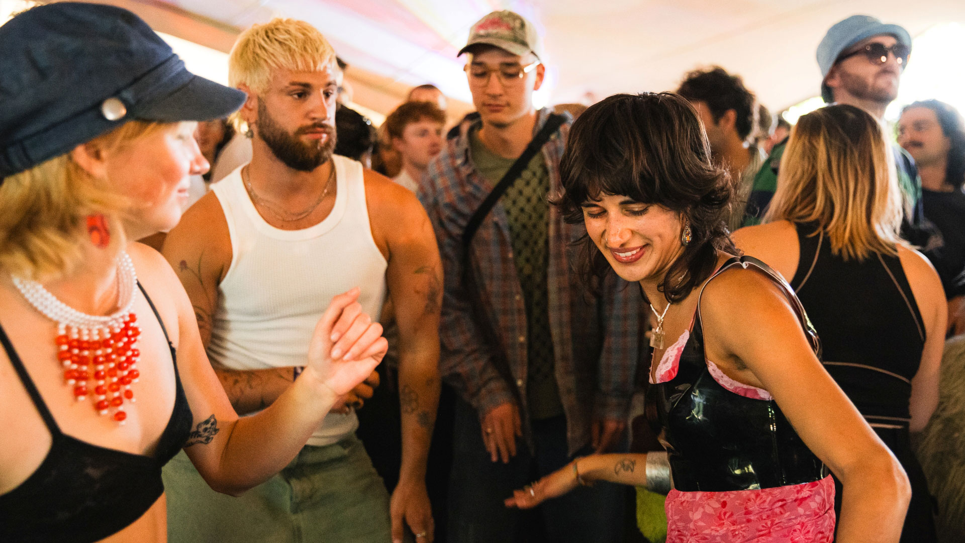 A photo of a group of friends smiling and dancing to the music together among a crowd of people at Waterworks festival
