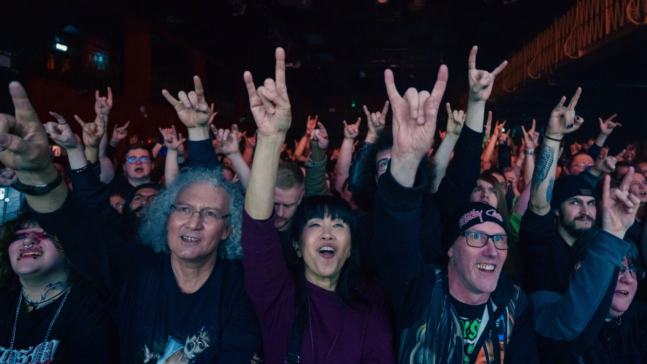 Fans throw up rock signs in the crowd at Electric Ballroom