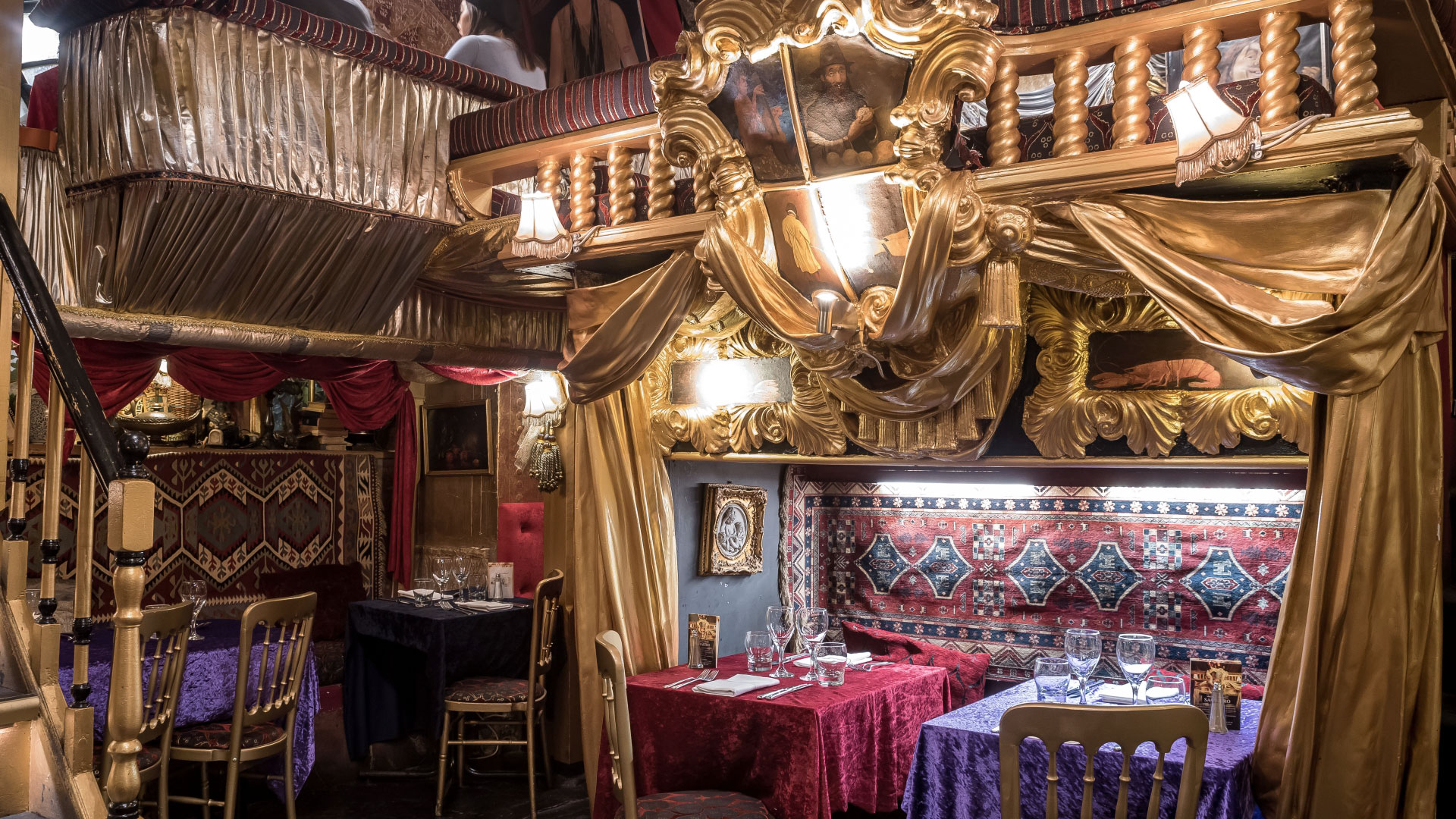 A photo of the interior of Sarastro restaurant with gold curtains framing the walls and decorated nooks to sit in 