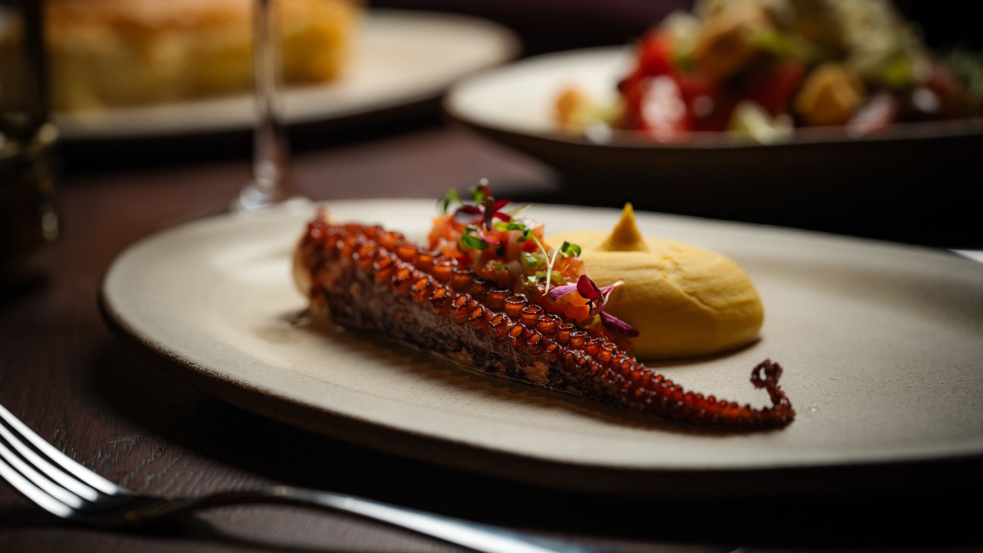 Octopus dish in centre with a fork below the plate.