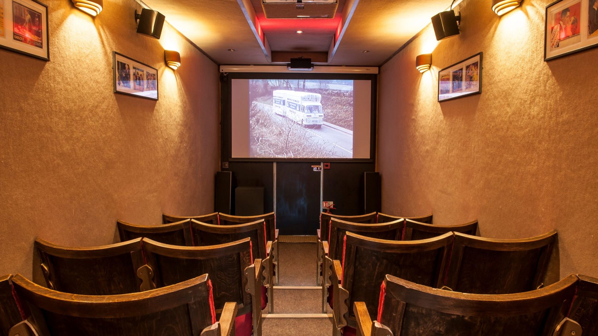 interior shot of an old bus transformed into a cinema space with chairs and projector screen