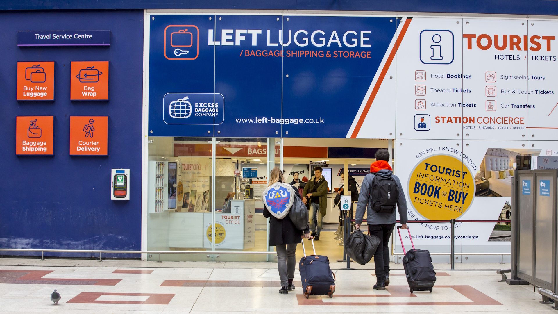 Two people walk into a left luggage facility at Victoria Station in London