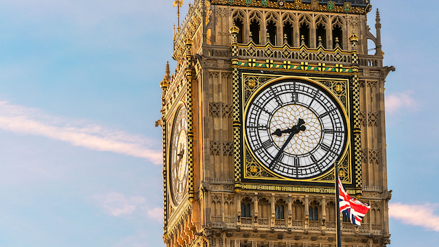 Drapeau de l'Union Jack vole devant le cadran de l'horloge de Big Ben à Londres par une journée ensoleillée.
