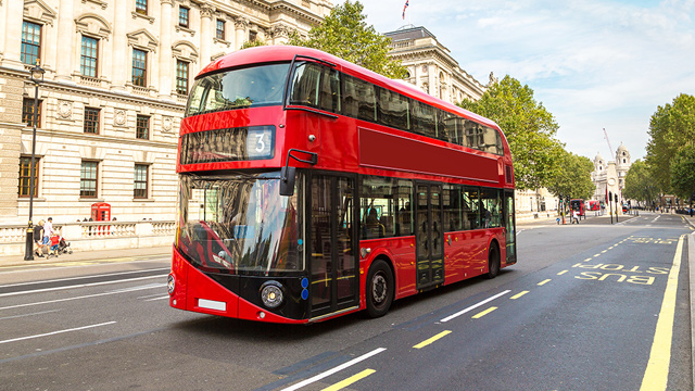 Un bus rouge à deux étages circulant dans Londres. Image reproduite avec l'aimable autorisation de Shutterstock. Un bus rouge à deux étages circulant dans Londres par une journée ensoleillée.